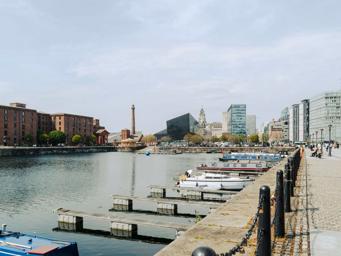 Boats moored at Liverpool's Albert Dock, looking across the water to the Royal Liver Building and the city skyline