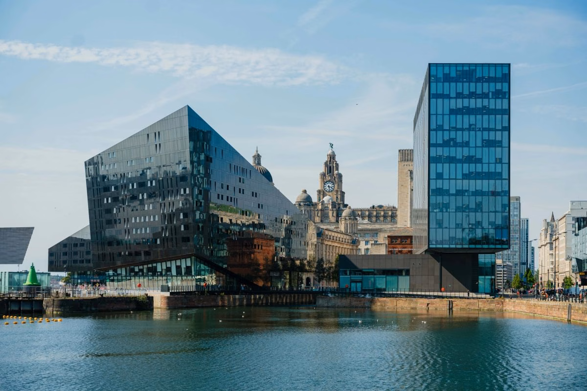 Liverpool's waterfront seen across Canning Dock, the Royal Liver Building's clock tower rising between the modern glass buildings on Mann Island
